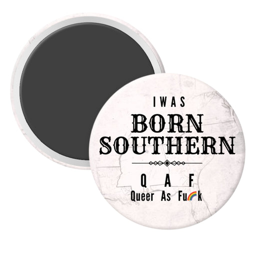 Round magnet with text 'I WAS BORN SOUTHERN QAF Queer As F**k' on a marble background