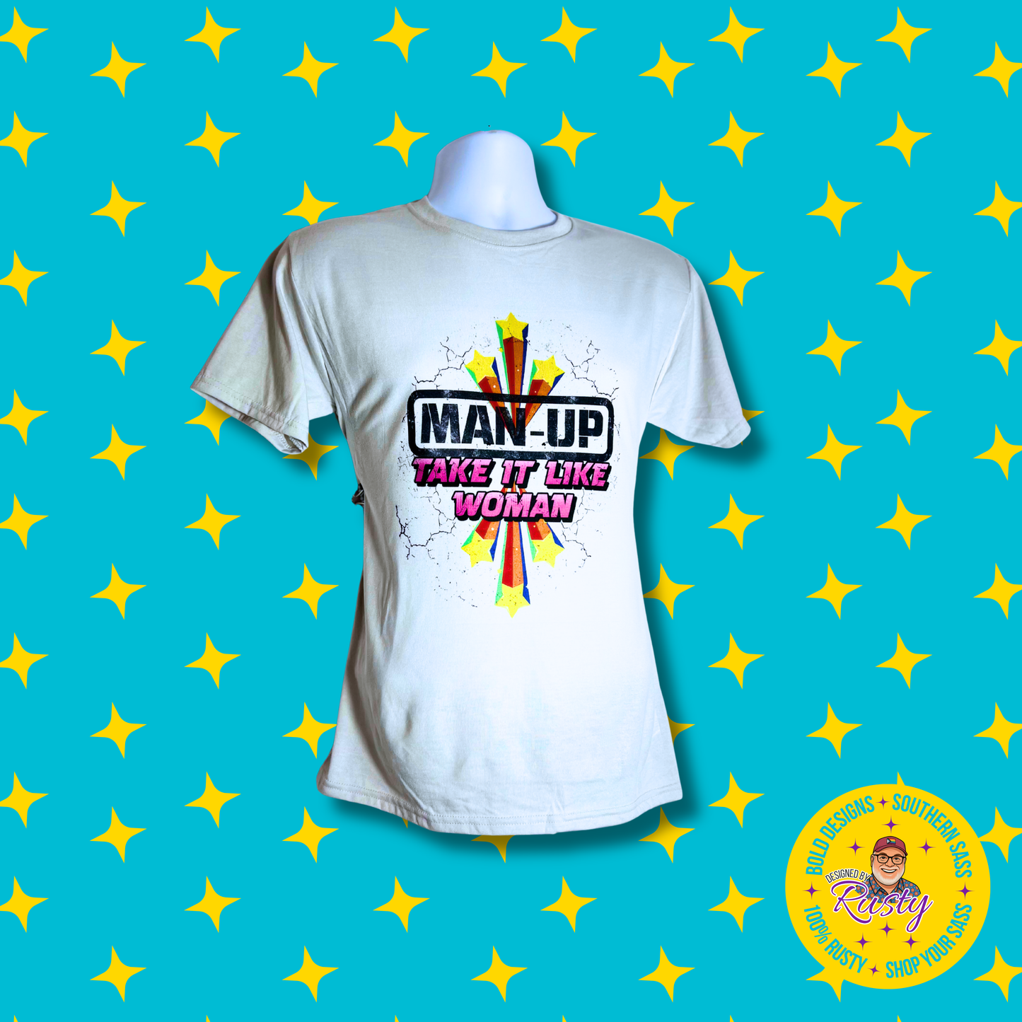 White unisex t-shirt with starburst design and “Man Up – Take It Like a Woman” text, on turquoise background with yellow stars and DBR logo.