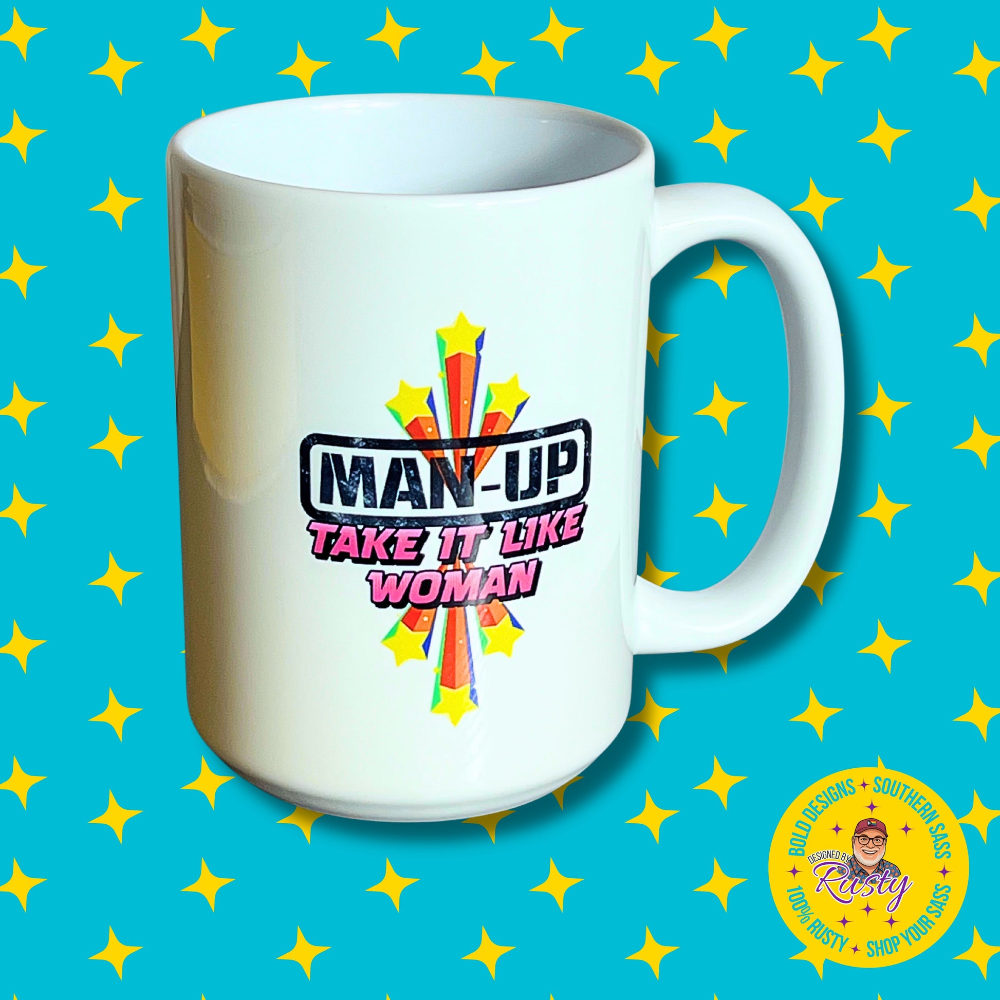 White 15 oz ceramic mug with starburst design and “Man Up – Take It Like a Woman” text, on turquoise background with yellow stars and DBR logo.
