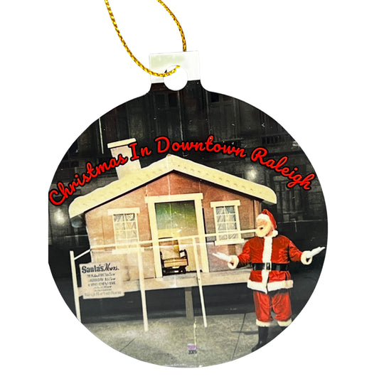 Round Christmas ornament featuring a vintage downtown Raleigh Santa scene with red text reading ‘Christmas In Downtown Raleigh.’
