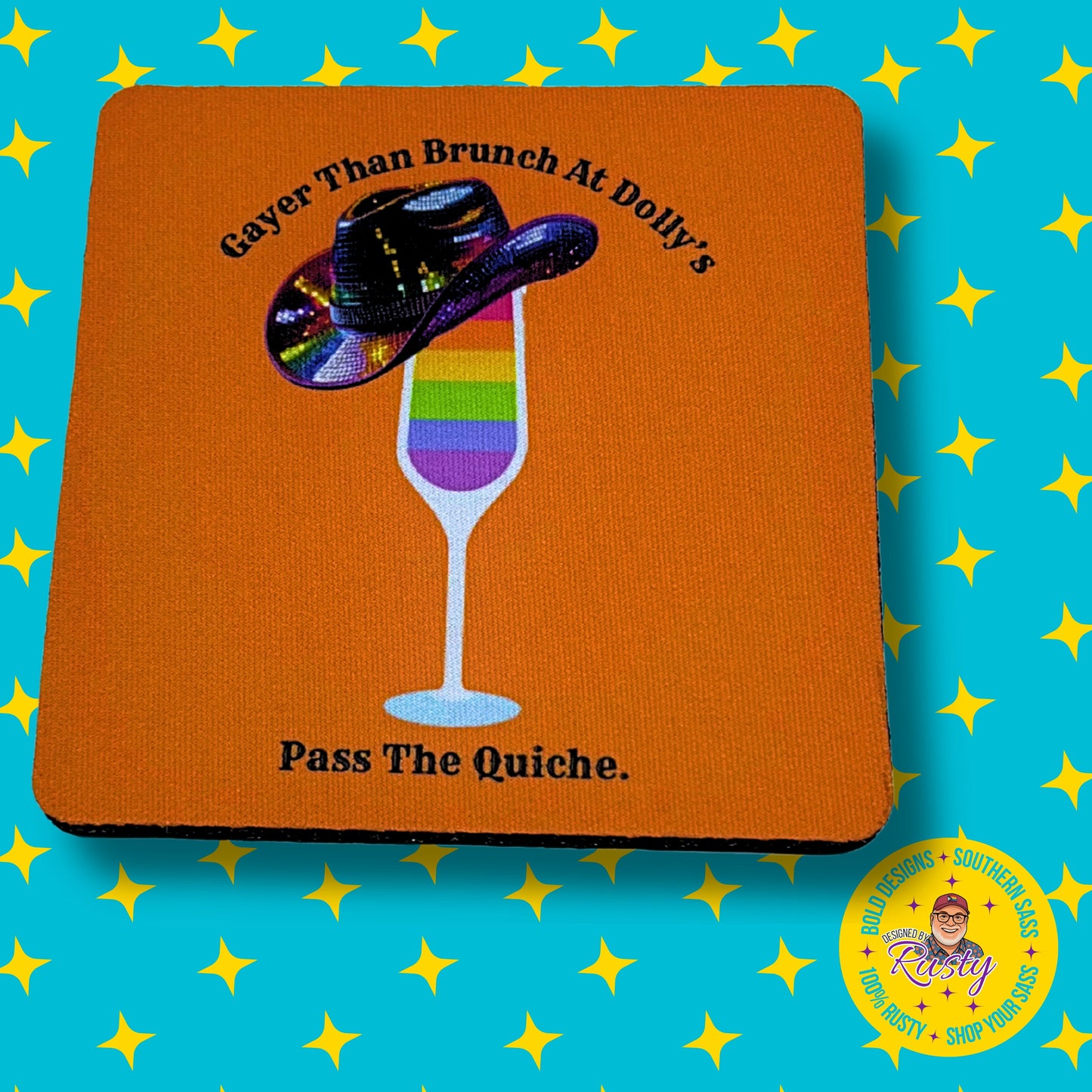 Orange coaster with rainbow mimosa and cowboy hat design reading “Gayer Than Brunch at Dolly’s – Pass The Quiche,” on turquoise background with yellow stars and Designed by Rusty logo.