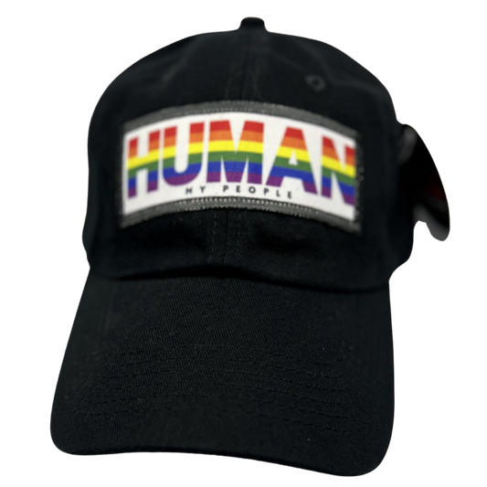 A black baseball cap featuring a rectangular front patch with the word 'HUMAN' in rainbow-colored letters and the smaller text 'MY PEOPLE' underneath, shown on a plain white background.
