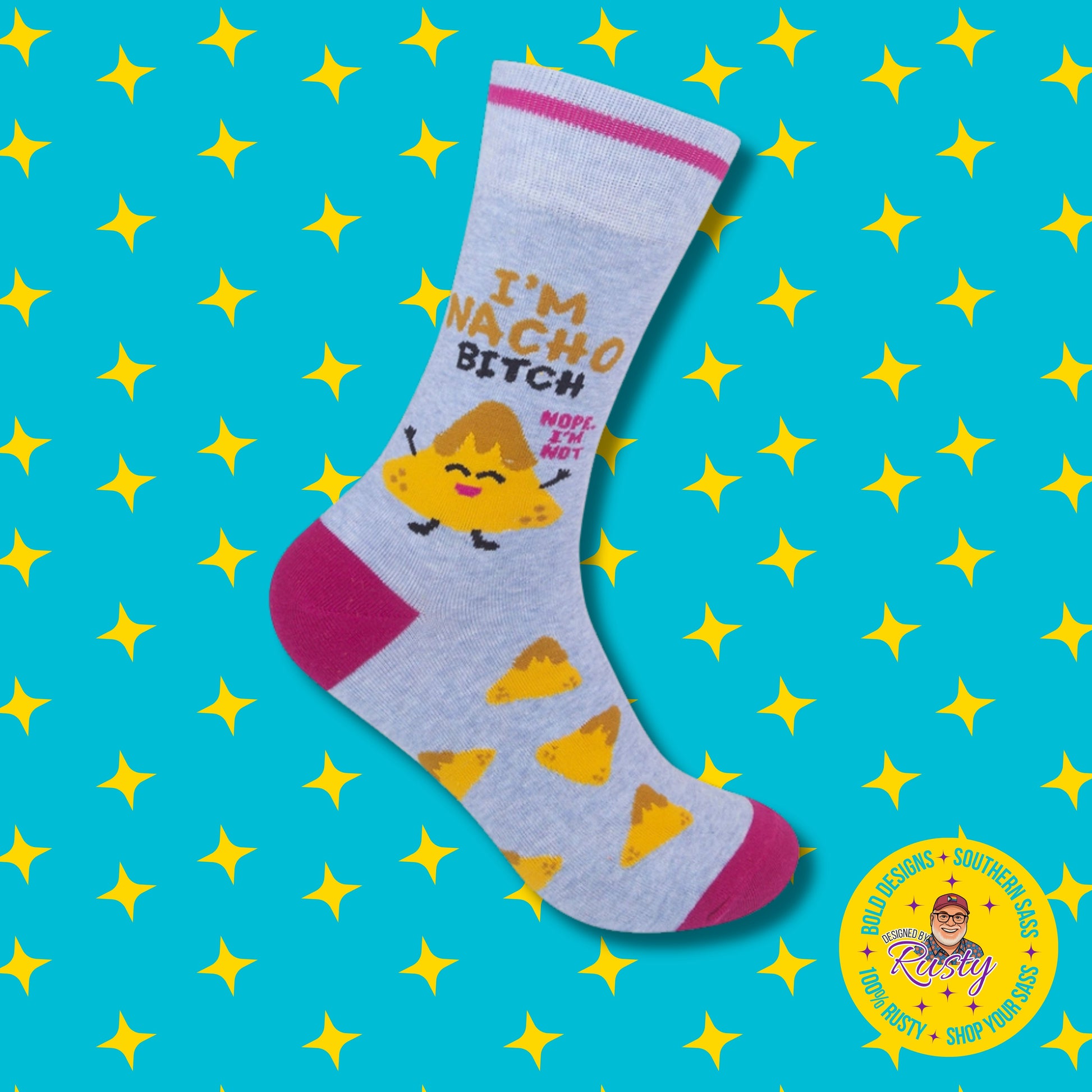 Light blue novelty crew socks with smiling nacho chip graphic and “I’m nacho bitch” text, on turquoise background with yellow stars and Designed by Rusty logo.