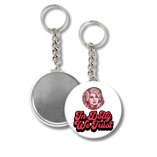 Keychain with a circular design featuring a portrait and text 'In Dolly We Trust' on a white background.