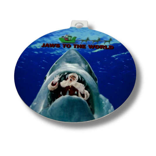Round Christmas ornament featuring Santa inside a shark’s mouth with the caption ‘Jaws to the World,’ printed on white background with red ribbon.