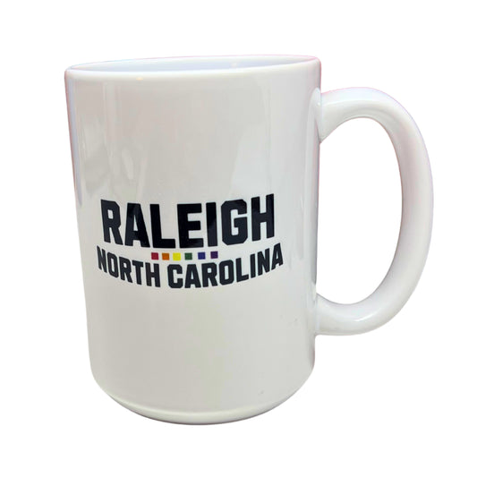 White ceramic 15 oz mug with bold black text “Raleigh North Carolina” and rainbow underline, displayed on pure white background.