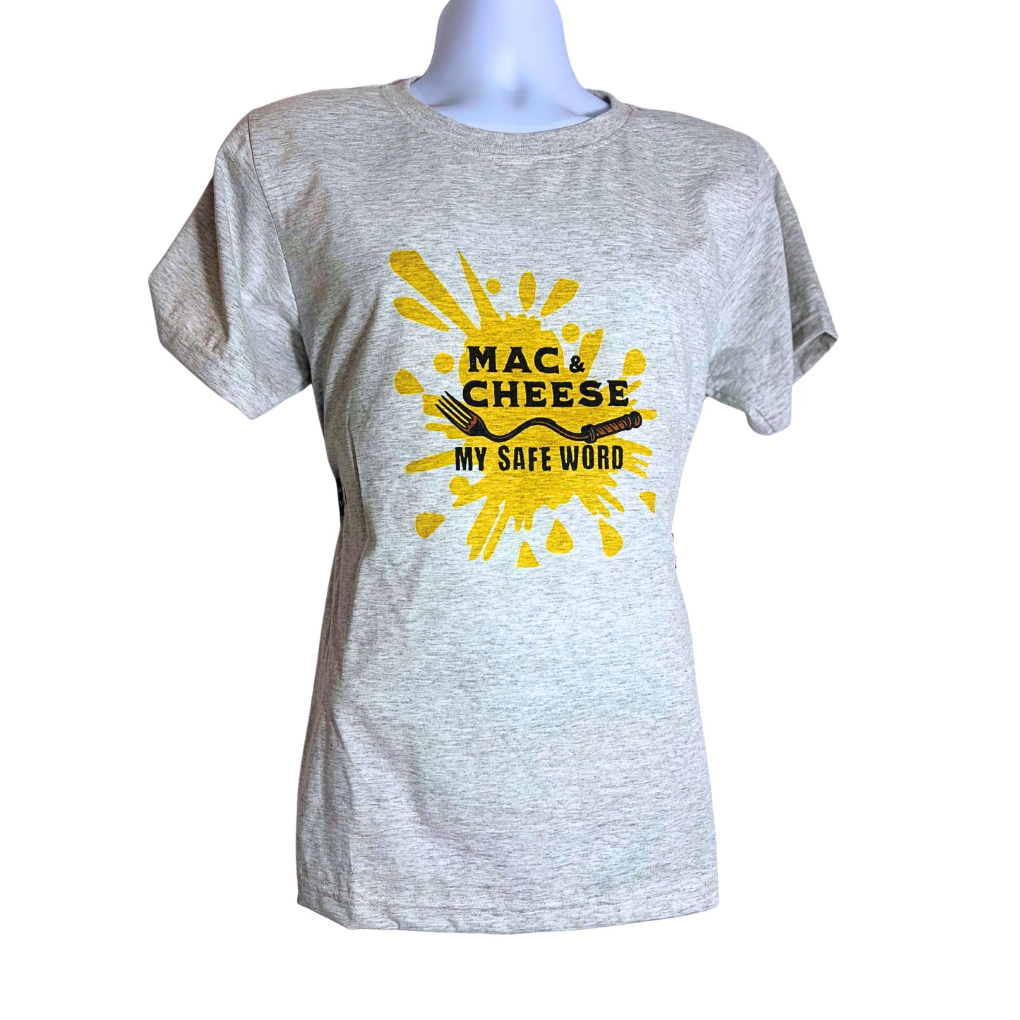 Light gray T-shirt with bold yellow splash design and black text reading “Mac & Cheese My Safe Word,” displayed on a mannequin against a pure white background.