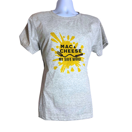 Light gray T-shirt with bold yellow splash design and black text reading “Mac & Cheese My Safe Word,” displayed on a mannequin against a pure white background.