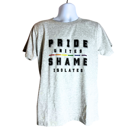 Light gray T-shirt with bold black text reading “Pride Unites, Shame Isolates” and a horizontal rainbow stripe between the words, displayed on a mannequin against a pure white background.