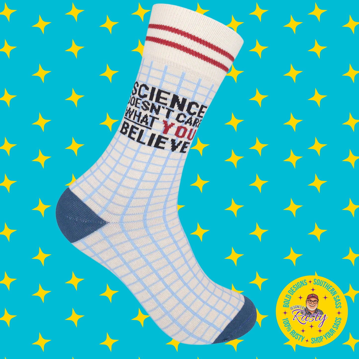 White novelty crew socks with blue grid design and text “Science doesn’t care what you believe,” on turquoise background with yellow stars and Designed by Rusty logo.