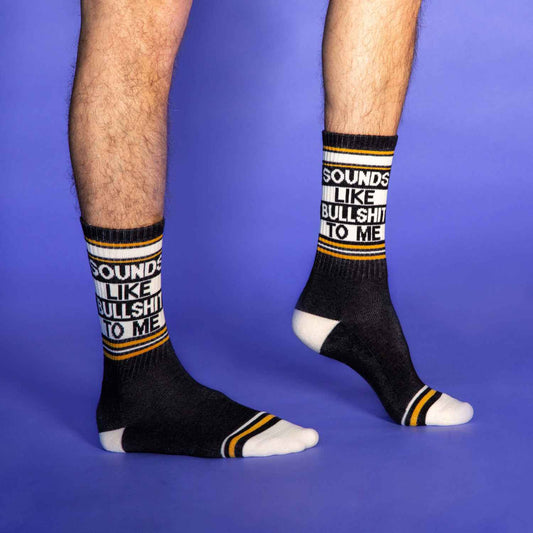 Model walking in black crew socks with bold white and yellow-striped text: “Sounds Like Bullshit To Me”